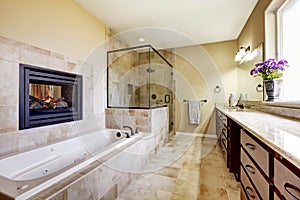 Master bathroom in modern house with fireplace and tile floor