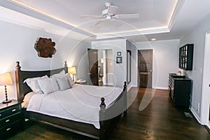 Master bedroom with king size bed and tray ceilings with uplighting and hradwood floors