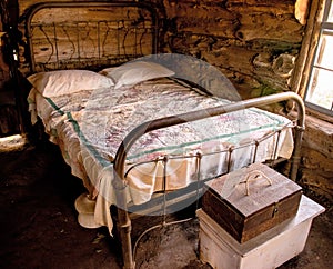 Master bedroom with a wrought iron bedstead in a pioneer cabin