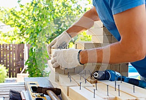 Master cabinetmaker makes wooden furniture with drill, nails, hammer. Handmade in home workshop