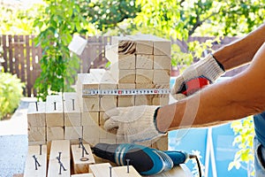 Master cabinetmaker makes wooden furniture with drill, nails, hammer. Handmade in home workshop