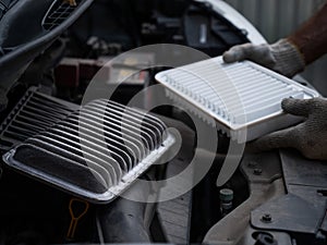 The master changes the air filter in the car engine.