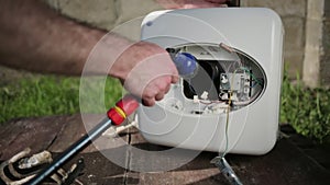 The master cleans the inside of the boiler using a hose with water. Close up of hands. Outdoor