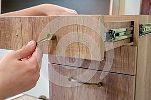 Assembling furniture, installing furniture decorative handles on the furniture facade