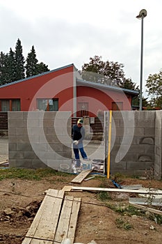 Master on the construction site, construction of a fence on a private territory, concrete type fence