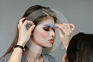 Master corrects the eyebrows of the model before shooting.