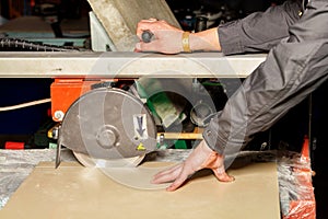 The master cuts a tile on an industrial machine with a diamond blade