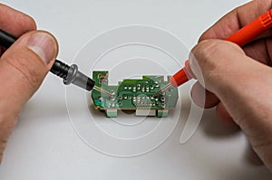 Master engineer tests and repairs microchip with multimeter