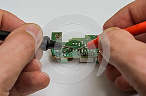 Master engineer tests and repairs microchip with multimeter