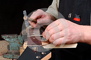 luthier establish frets in the neck of the guitar photo