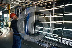 Master glues spacer frames at a window factory
