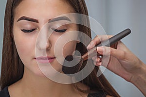 Master inflicts brush powder on the face of the girl, completes