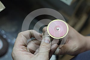 The master jeweler holds the working tool in his hands and makes jewelery at his workplace