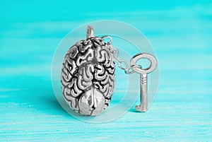 Master key chained to a human brain on blue