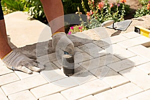 The master lays paving stones in layers. Garden brick pathway paving. Laying concrete paving slabs in house courtyard on sand