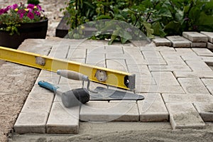 The master lays paving stones in layers. Garden brick pathway paving. Laying concrete paving slabs in house courtyard on sand