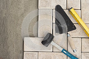 The master lays paving stones in layers. Garden brick pathway paving. Laying concrete paving slabs in house courtyard on sand