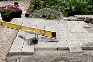 The master lays paving stones in layers. Garden brick pathway paving. Laying concrete paving slabs in house courtyard on sand