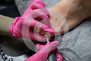 The master makes hardware pedicures to the client. Cuticle treatment.