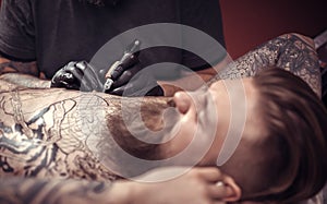 Master makes a tattoo on the skin in salon