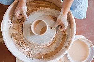 Master making a pot on pottery wheel, top view