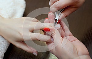 The master of the manicure cuts the cuticles on the hands in the beauty salon. photo