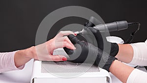 The master of the manicure saws and attaches a nail shape during the procedure of nail extensions in the beauty salon.
