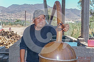 master mezcalero distilling mezcal in oaxaca photo