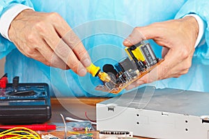 Master parses electronic hardware for repair in service workshop