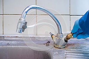 The master plumber changes the valve in the old faucet in the kitchen.