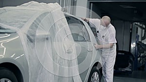 Master polishes the bumper with a cloth.