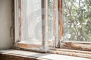 Master removes old paint from window with heat gun and scraper. Closeup.