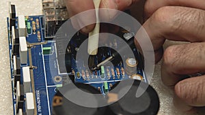 Master repairman performs pin diagnosis with a tester on the blue electronic board. Repair shop for electronics, computers, phones