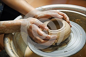 Master`s hands mold a jug on a potter`s wheel