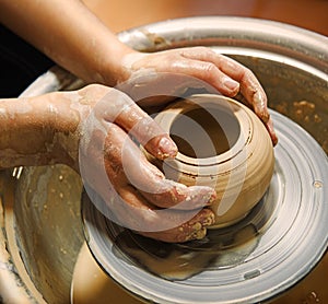 Master\'s hands mold a jug on a potter\'s wheel