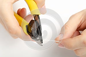 Master`s hands with optical fiber stripper, closeup optical fiber. Isolated background