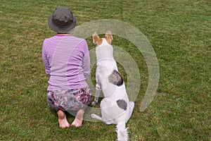 Master shows to young dog how to perform sit command