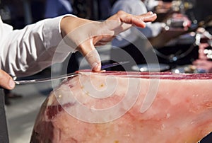 Master slicer holds the slice of iberian cured ham