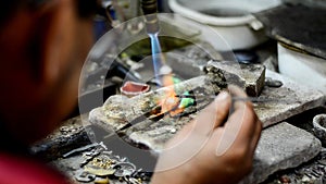 Master soldering jeweller ornament. Picture of hands and product