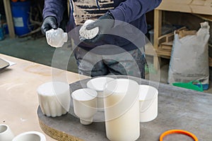 The master takes out plaster products from a silicone mold.