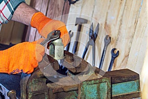 Master tightens the bolt with a key, the working environment in the workshop