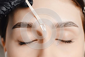 Master wax depilation of eyebrow hair in women, brow correction photo