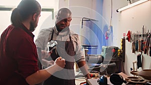 Master in woodworking shop giving worker protection gloves