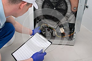 The master writes down the number of the fault in the breakdown of the washing machine, during the repair, specifying the cost