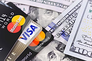 MasterCard and Visa with dollars banknotes