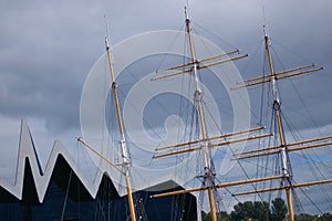 The masts of an old sailing ship moored to the pier