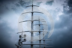 Masts of Sail modern Yacht against dramatic cloudy sky.