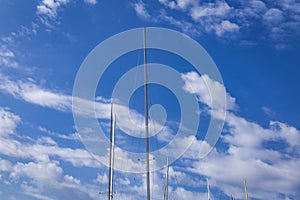 Masts of sailing ships yacht on blue sky background in marina