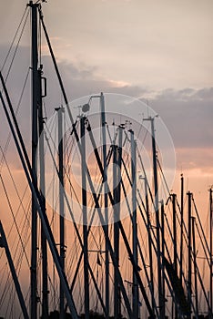 Masts of sailing yachts on the background of the setting sun