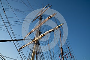 Masts, spars and rigging from low point of view against blue sky